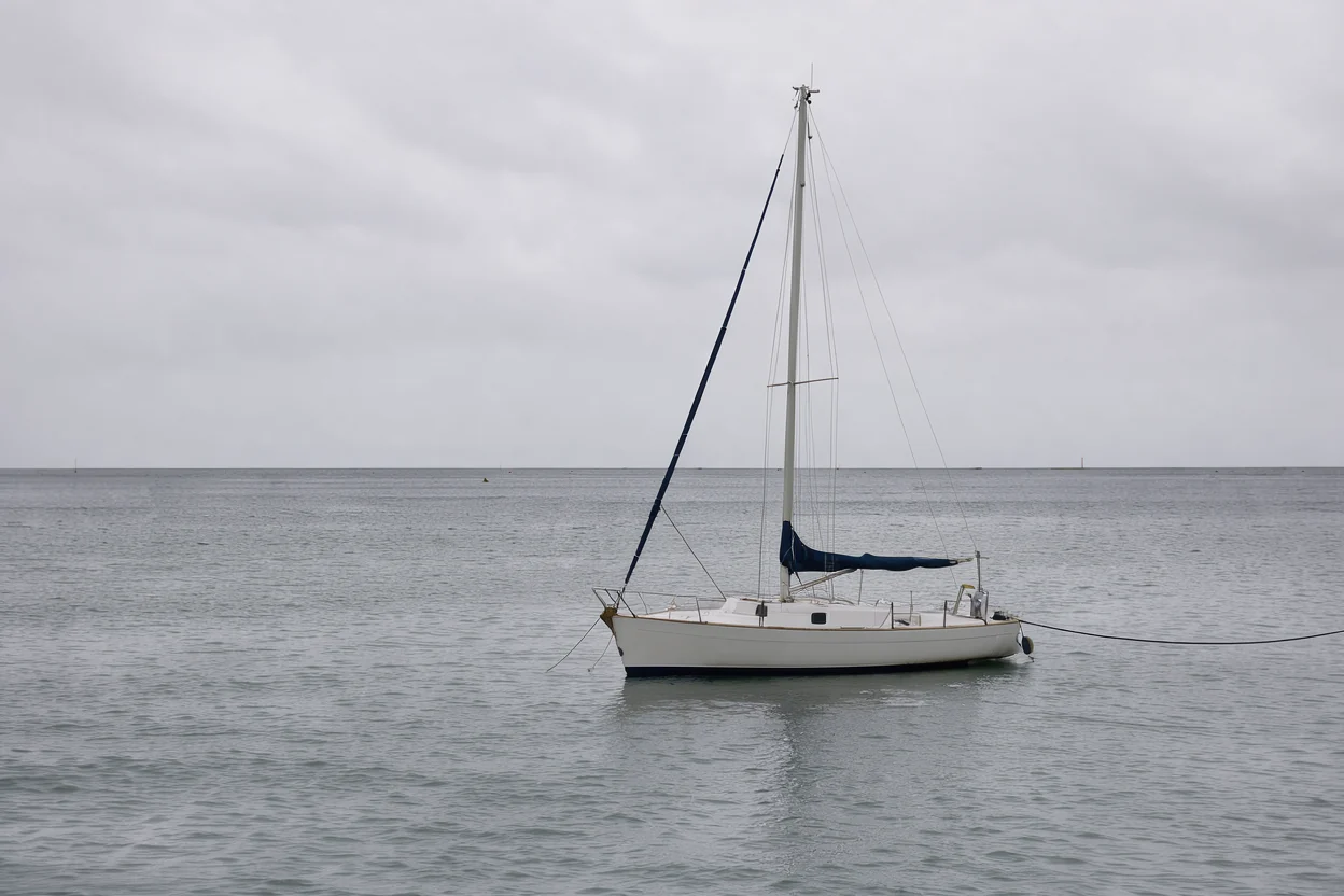 reference photo of a small white sailing boat in a grey harbour